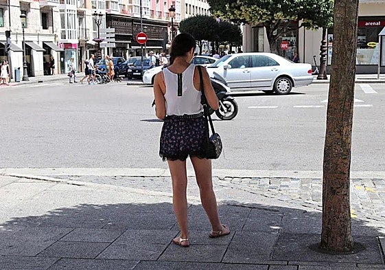 Una mujer, resguardándose a la sombra en un día de calor en Burgos