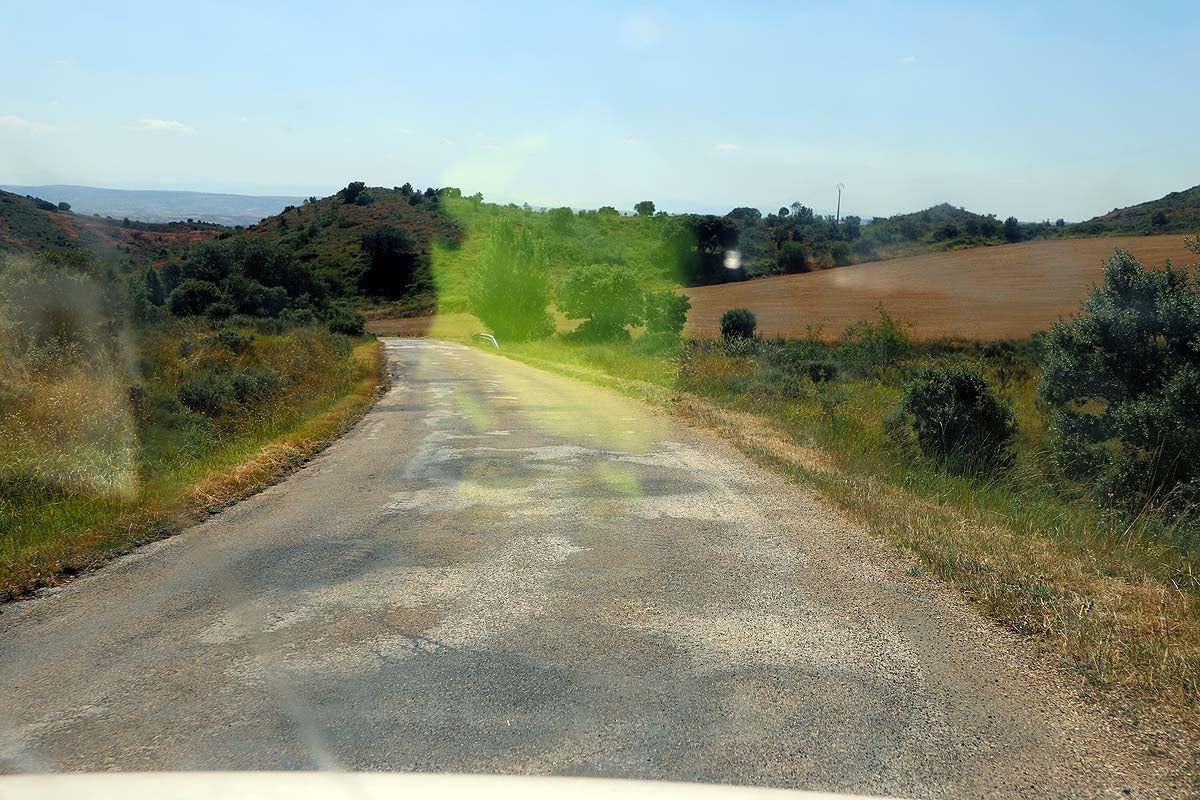 Carretera en mal estado, estrecha, con curvas y en pendiente que lleva a Abajas.