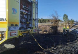 Medios de extinción trabajando en el fuego cercano a la carretera.