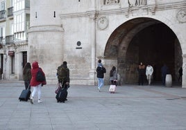 Turistas con sus equipajes en el arco Santa María de Burgos.