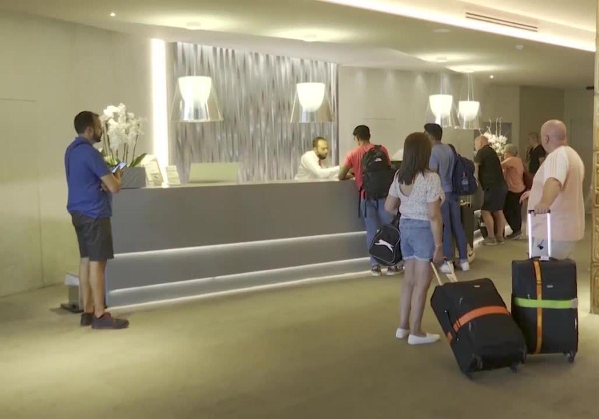 Turistas esperan su turno para registrarse en un hotel.