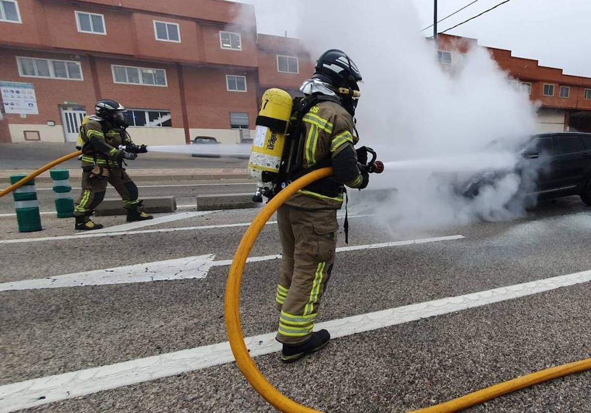 Los Bomberos de Burgos sofocan las llamas en el vehículo incendiado en plena carretera.