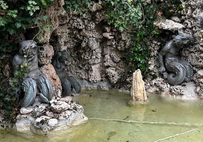 Dos tritones, una sirena y una estalagmita sujetan la gruta.