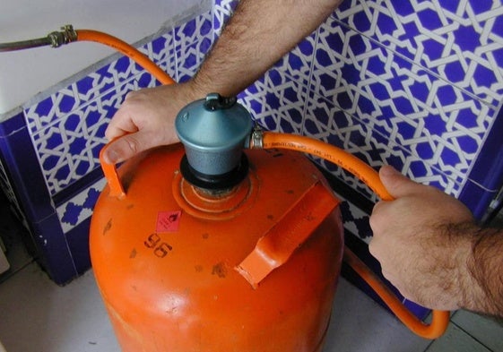 Imagen de archivo de un hombre manipulando una bombona de gas.
