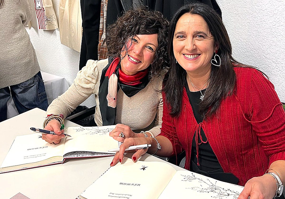 Escribano y Domaica firmando libros.