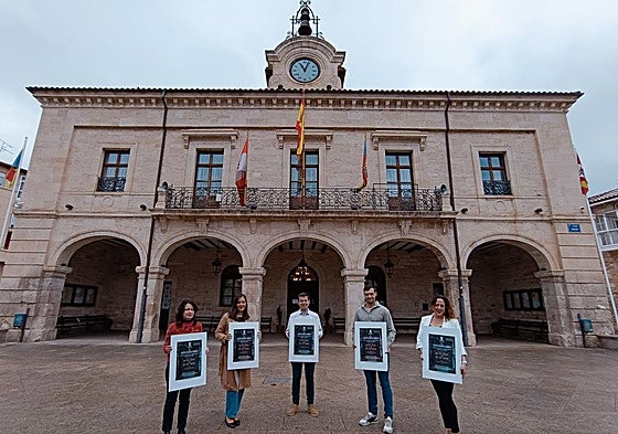 Concejales y alcalde con el cartel del L Aniversario de la fusión de los Ayuntamientos.