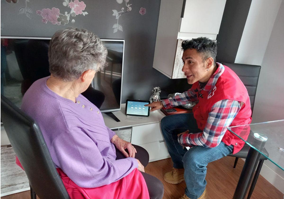 Un voluntario del programa 'Voces en Red' instruye a una persona mayor