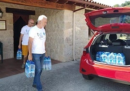 Dos vecinos de Fresnedo recogían agua embotellada de la Casa del Concejo cuando no podían consumir la del grifo.