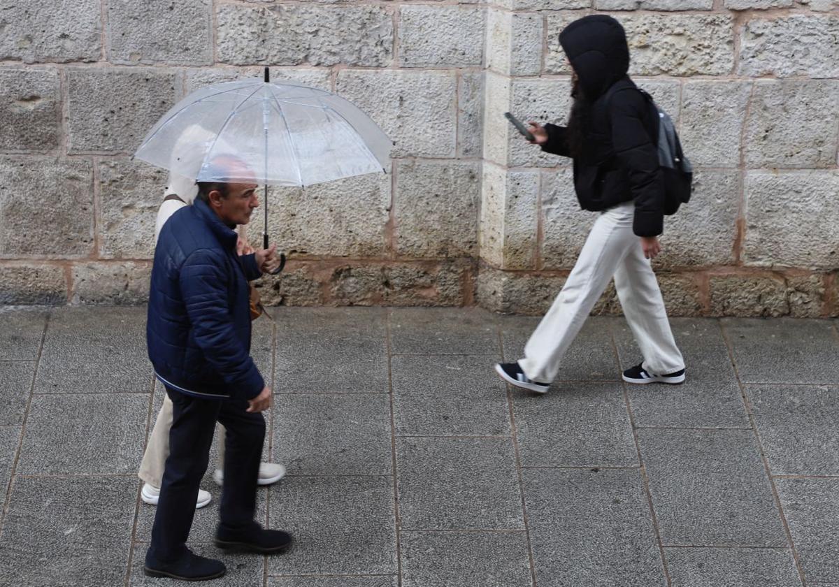 Una pareja se protege de la lluvia con un paraguas.