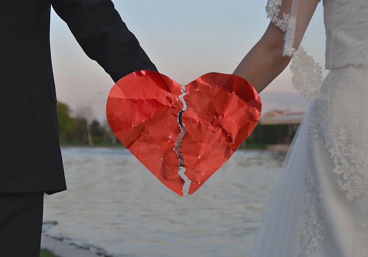 Imagen de una pareja recien casada en la que se puede ver en medio de la imagen un corazón roto
