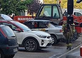 Los Bomberos de Aranda trabajan en el lugar del coche incendiado.
