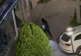 Uno de los ladrones entrando al establecimiento y el coche blanco con el que se ha realizado el alunizaje en la perfumería de Aranda.
