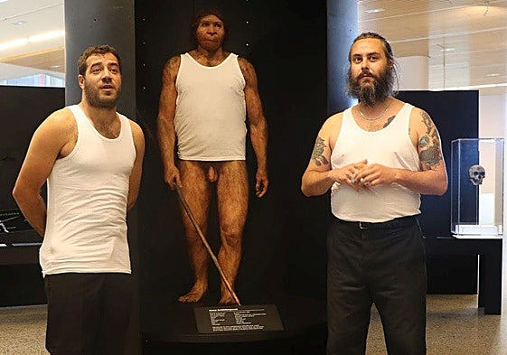 Álvar y Jorge (La Moda) custodian al anfitrión del evento en el MEH, Miguelón, en la sala de los homínidos, después de imponerle la camiseta del grupo.