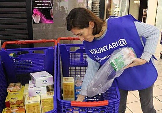 Voluntaria recoge productos en la sede del Banco de Alimentos.