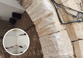 Arco del Amparo, en el barrio de Huelgas, con las marcas de las rozaduras de vehículas y, en miniatura, las grietas de las casas cercanas.