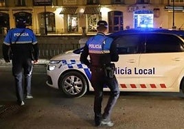 Dos agentes de la Policía Local de Burgos junto al coche patrulla.