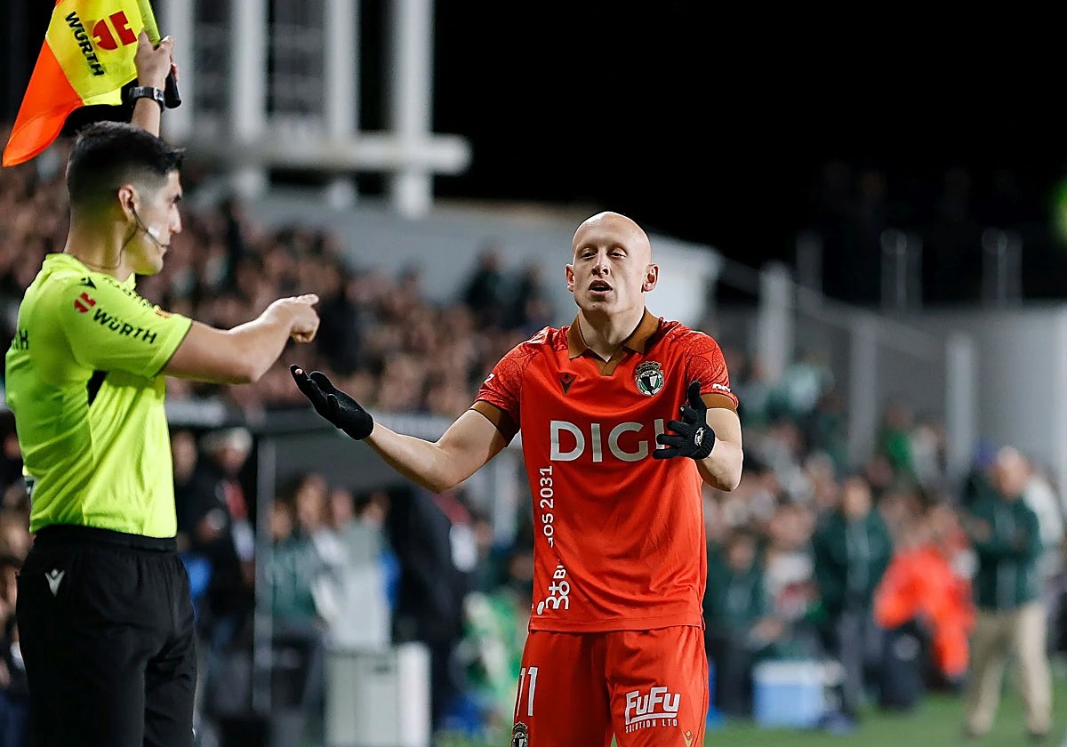 Un árbitro auxiliar de banda señala a Víctor Mollejo, que eleva su queja.