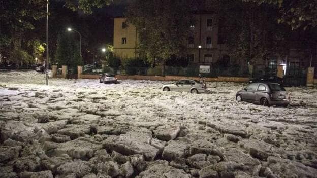 Tres coches se quedan atrapados en una carretera completamente cubierta por un manto de granizo, en Roma, Italia, la noche de ayer, 21 de octubre de 2018. Otras ciudades como Florencia y Pisa también han resultado afectadas por fuertes tormentas y lluvias torrenciales. / Efe.