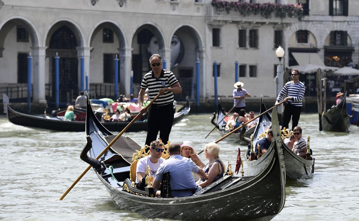 Un grupo de turistas pasea en una góndola en Venecia (Italia) 