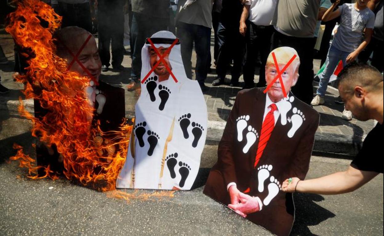 Palestinos queman fotografías de Trump, de Netanyahu y del príncipe heredero de Abu Dabi en señal de repulsa por el pacto.