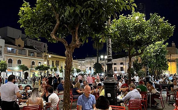 Imagen principal - Ambiente en la plaza del Cabildo (arriba), playa de Sanlúcar de Barrameda (centro) y basílica de la Caridad.
