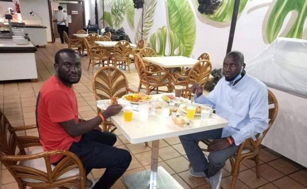 Dos hombres comen en el hotel donde fueron alojados por la Delegación