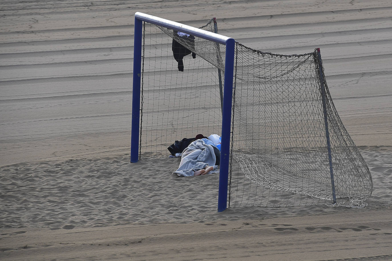 Una persona duerme en Las Alcaravaneras. 