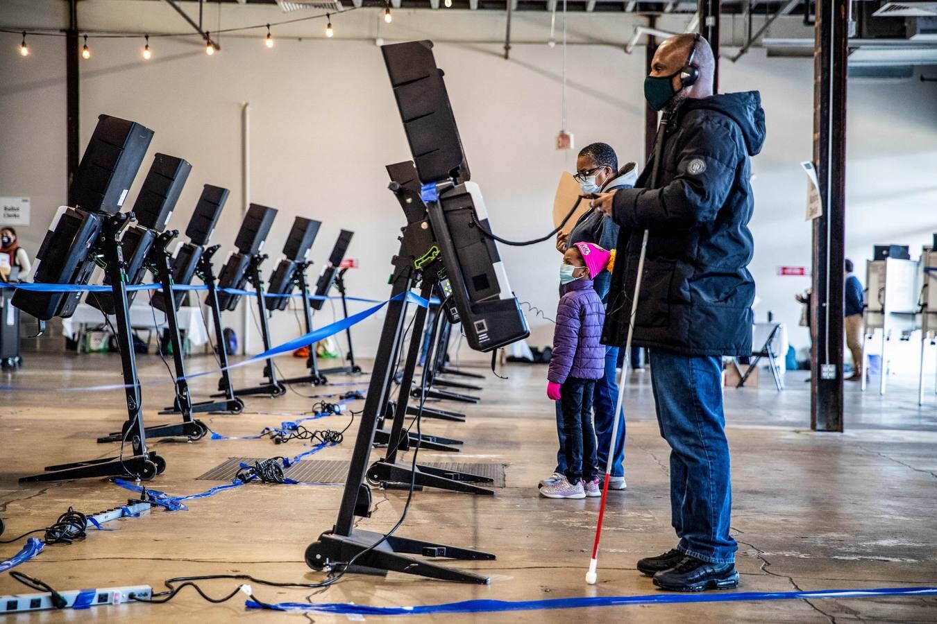 Un votante ciego usa un teclado y auriculares para completar su derecho en Union Market en Washington.
