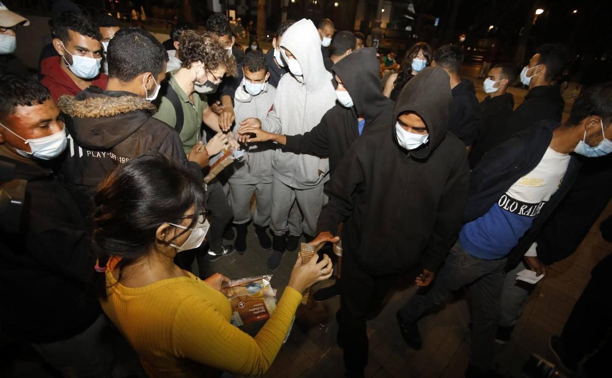 Reparto de alimentos entre los irregulares, en horas de la noche del martes en la plaza hasta adonde fueron trasladados.. 