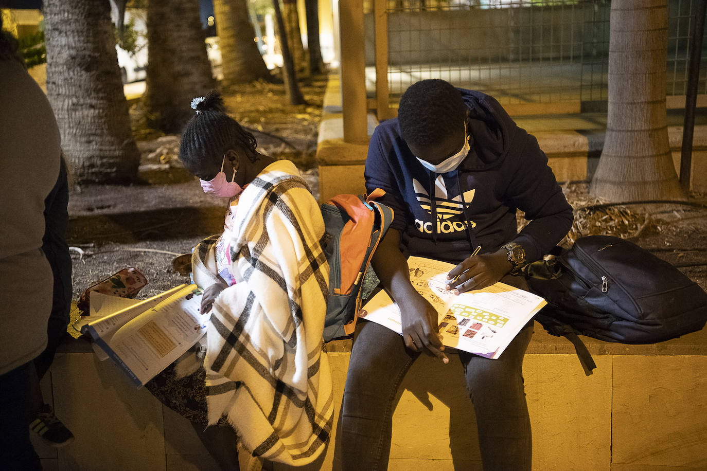 Esto también es España. Niños tirados en la calle y haciendo los deberes como pueden. 