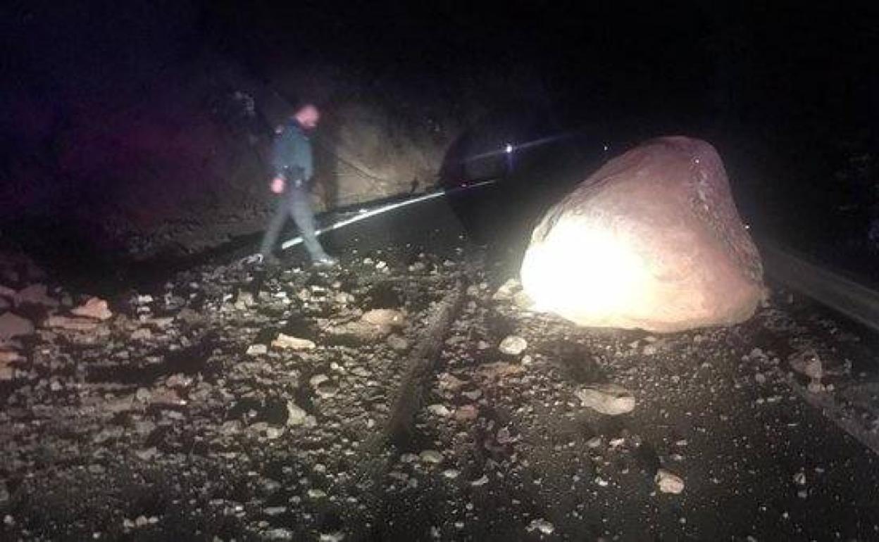 Imagen de Carreteras de Gran Canaria en la que se aprecia la piedra de grandes dimensiones junto a un agente de la Guardia Civil. 