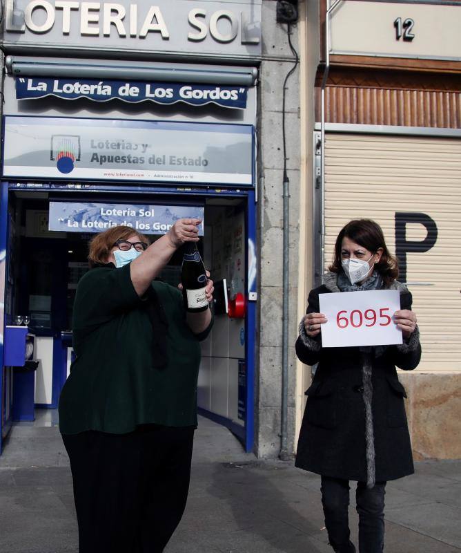 Loteras de "La Lotería de los Gordos", en la céntrica Puerta del Sol de Madrid, festejan tras repartir décimos del 6095, agraciado con el segundo premio del Sorteo Especial de Lotería de Navidad