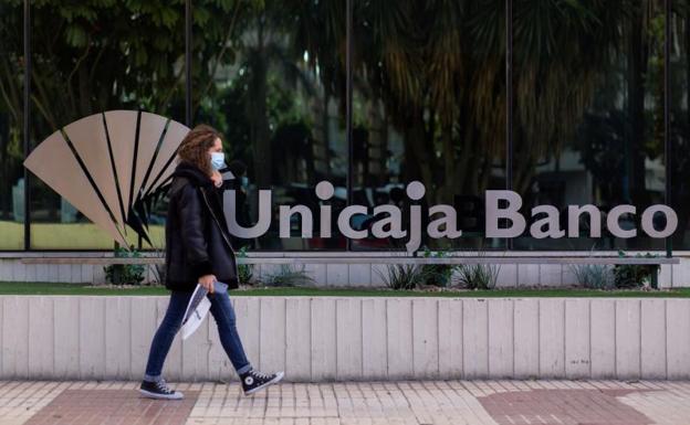 Una mujer pasa frente a la sede de Unicaja en Málaga 