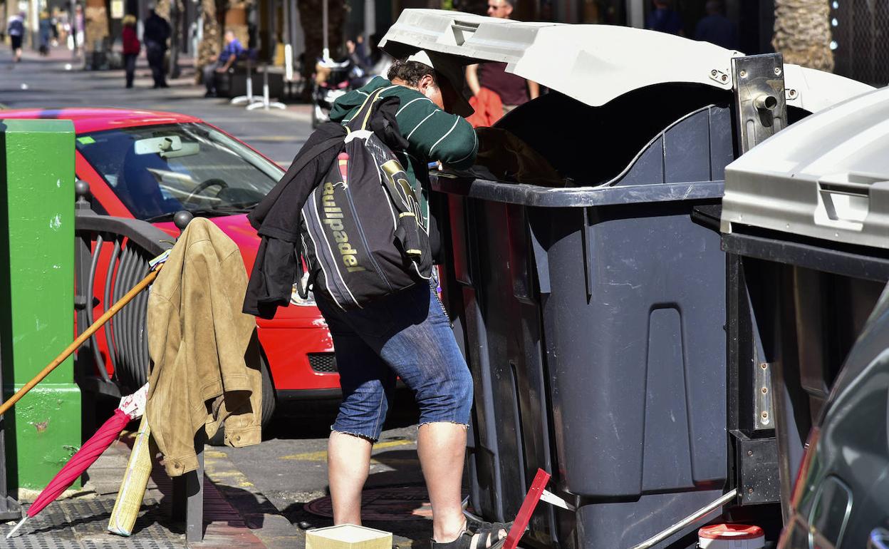Una persona busca comida en un contenedor en Las Palmas de Gran Canaria. 