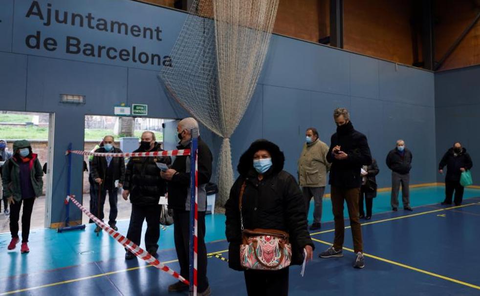 Ciudadanos hacen cola para votar en el polideportivo Can Ricart del barrio del Raval de Barcelona.