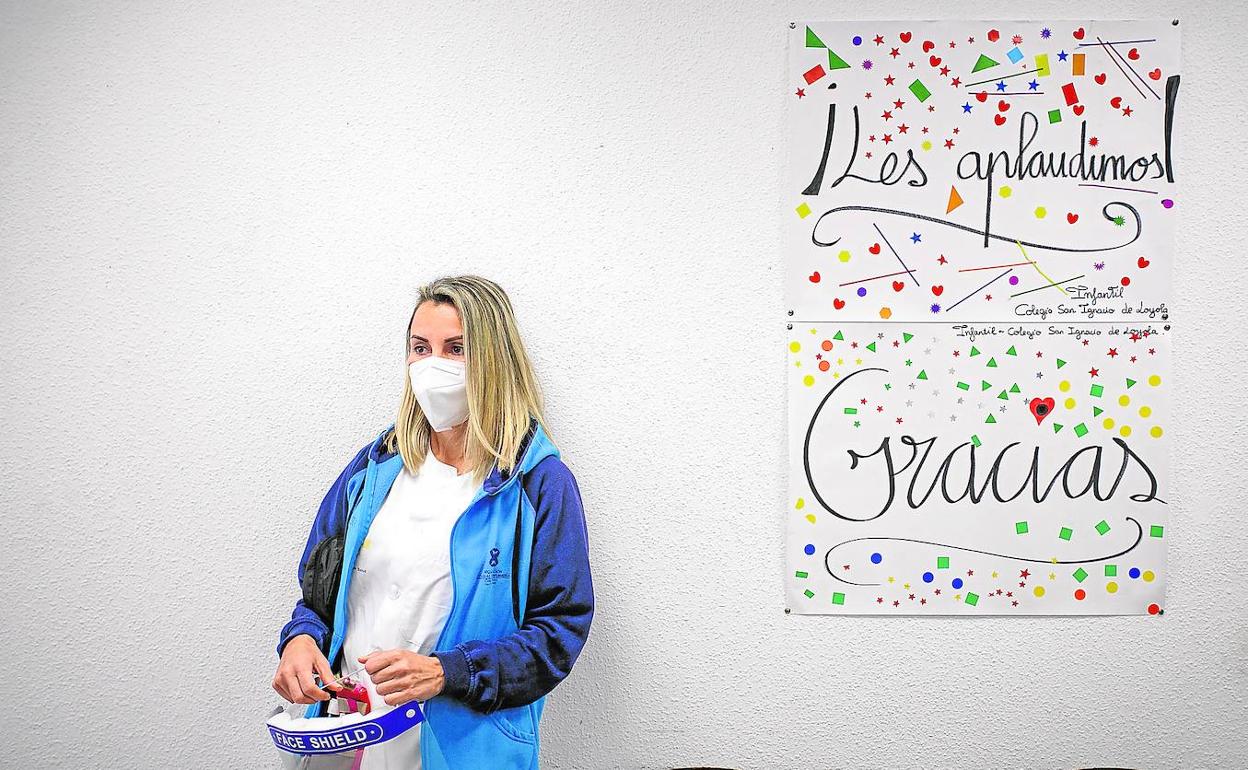 La enfermera María Valle, en el centro de salud de El Calero, junto a un dibujo hecho por escolares a los que se les hizo un cribado en busca del coronavirus.