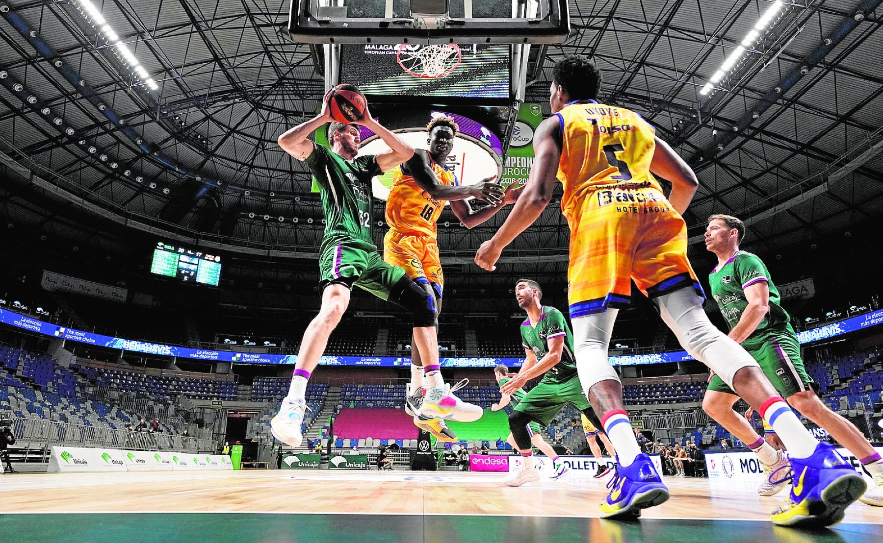 El pívot andaluz del Unicaja, Rubén Guerrero, se hace con el rebote ante la presencia del canterano del Granca Khalifa Diop. 