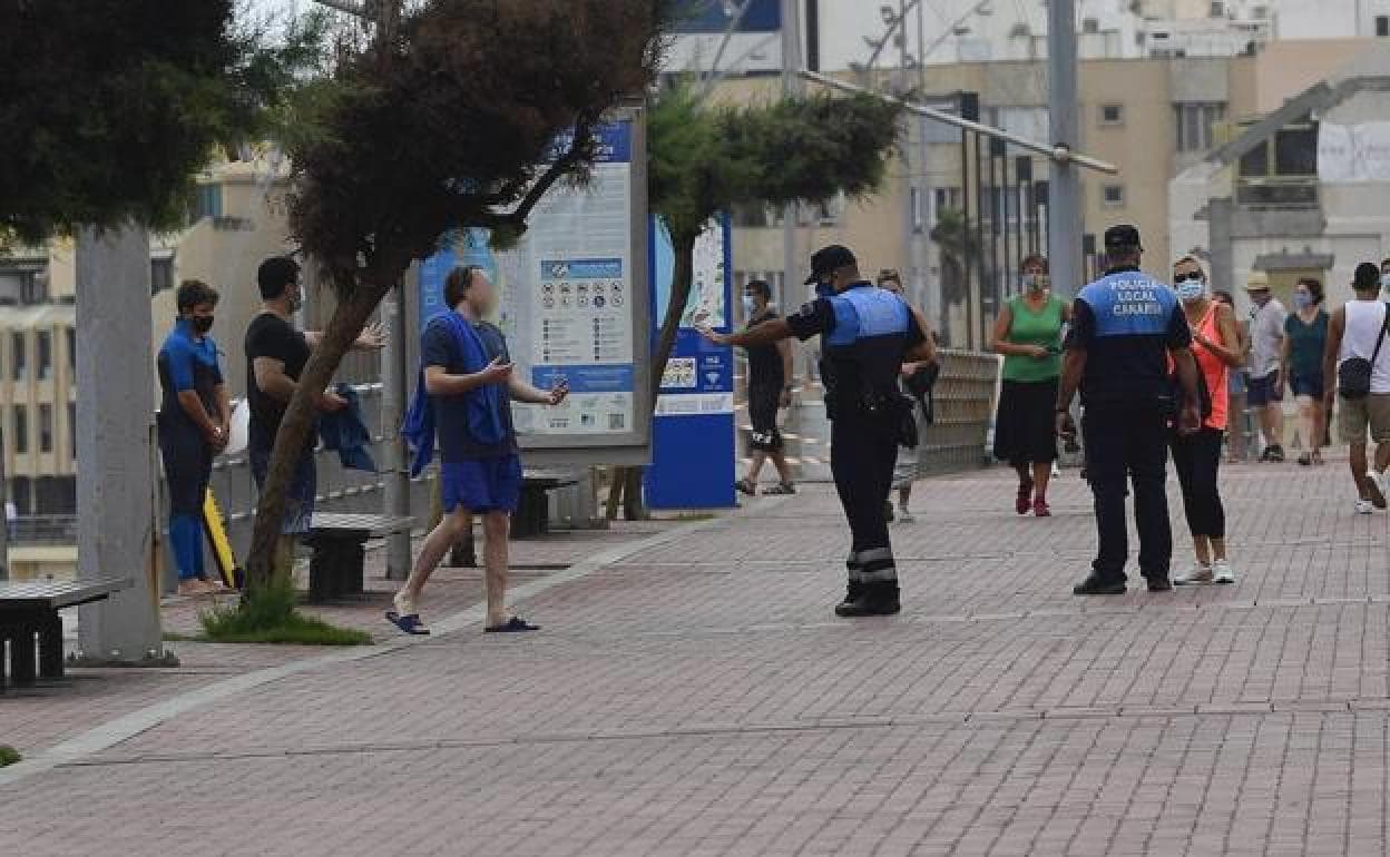 Dos agentes controlan el uso de las mascarillas en Las Canteras. 