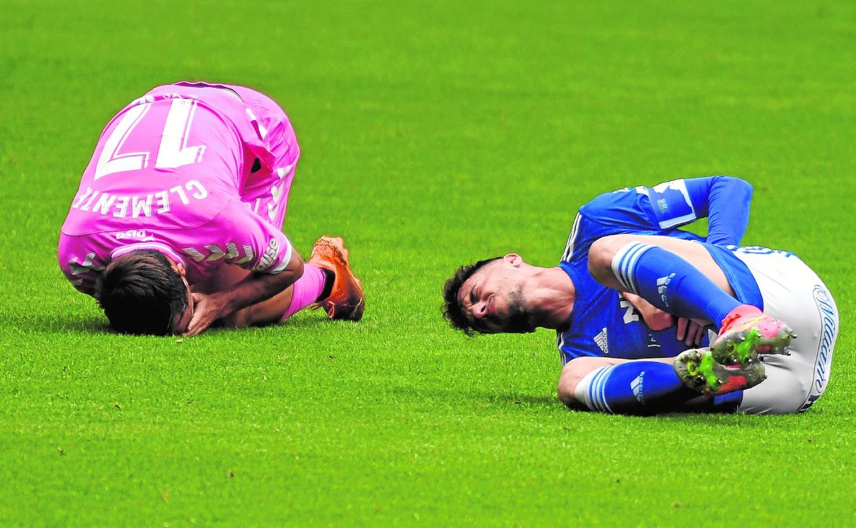 Clemente, dolorido en el suelo, luego de un choque fortuito con Tejera, el pasado sábado en el Nuevo Carlos Tartiere. 