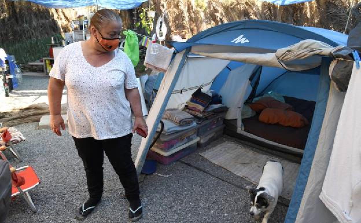 Loli, junto a su perra Pétalo, en el espacio que se ha habilitado para vivir bajo un tarajal.