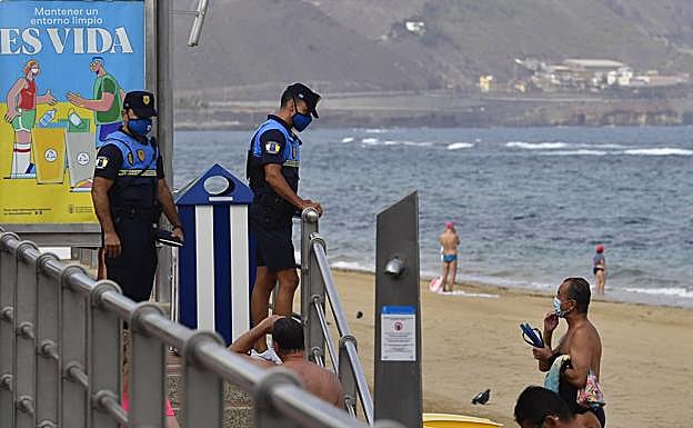 Imagen de archivo de una pareja de policías controlando el uso de las mascarillas en la playa de Las Canteras. 
