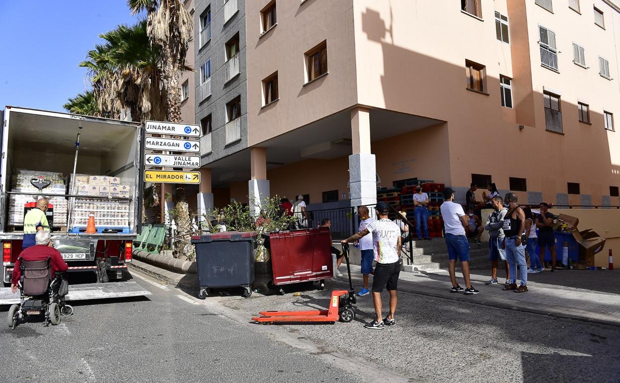 Descarga de productos alimenticios por parte de voluntarios que colaboran con la asociación Guaxayra Aguax, en Jinámar. 