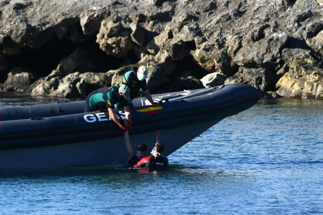 Agentes del grupo acuático de la Guardia Civil rescatan a un migrante.