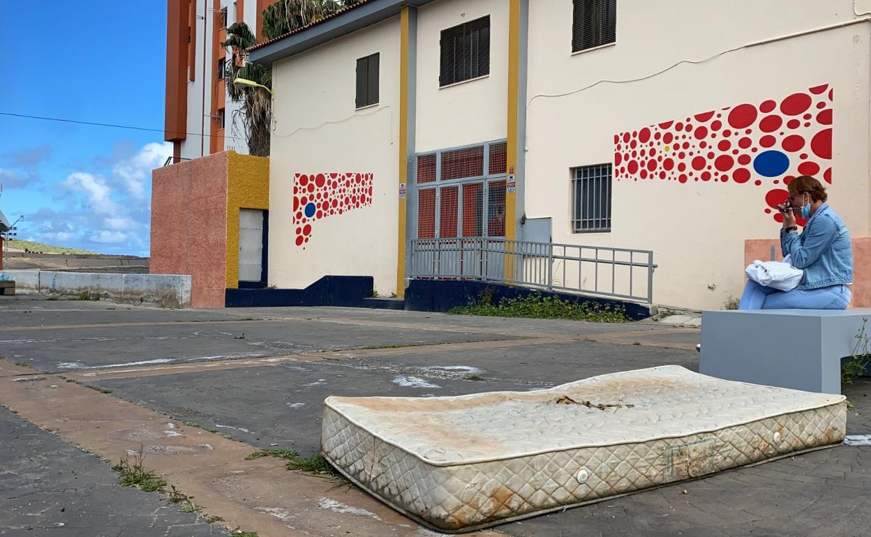 Una antigua usuaria del centro para personas sin hogar habla por teléfono delante del Pedro Lezcano, la instalación que acogía el servicio. 