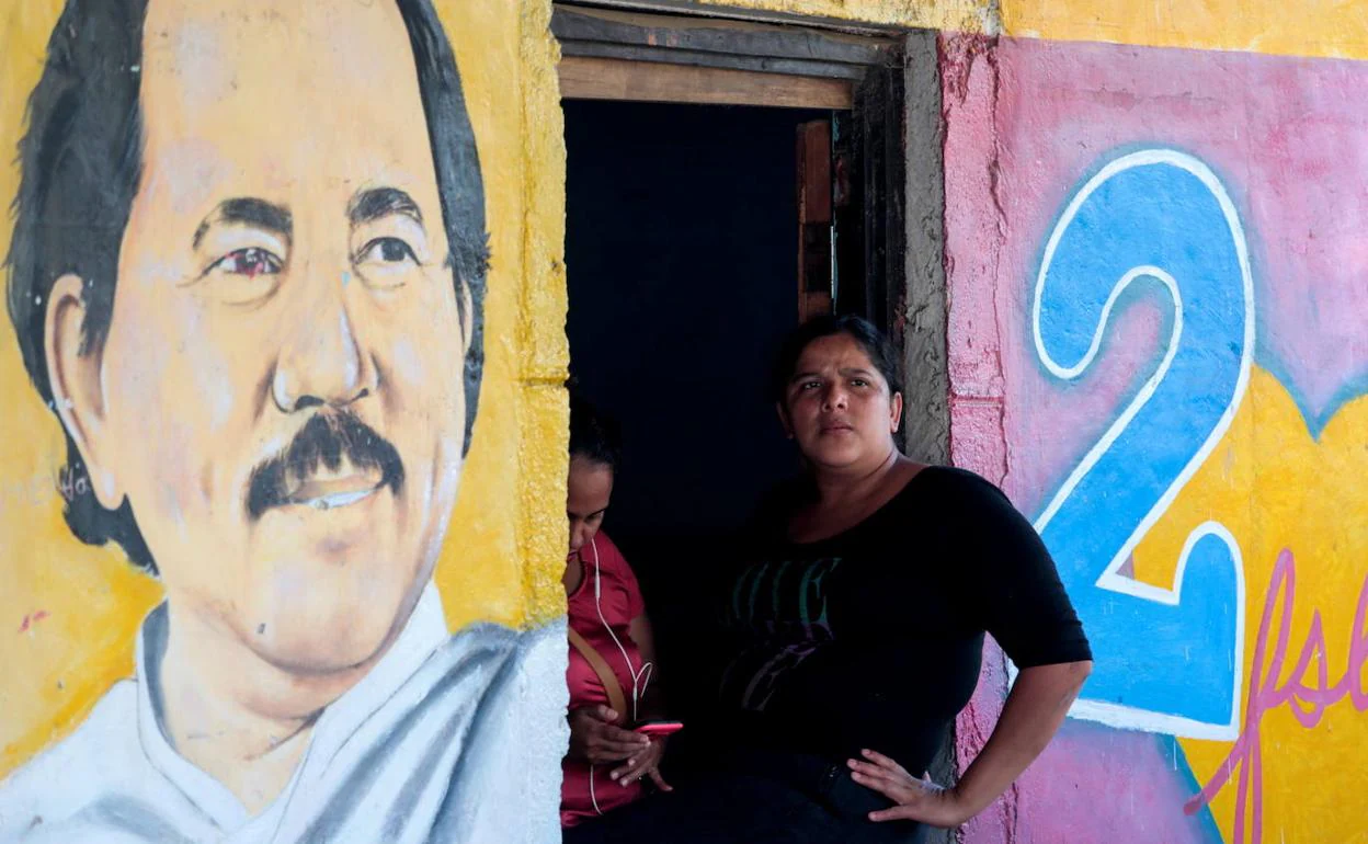 Una mujer posa junto a una pintada con la imagen de Daniel Ortega en la localidad de Catarina, Nicaragua.