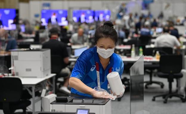 Una empleada desinfecta equipos en el centro de prensa de los Juegos de Tokio. 