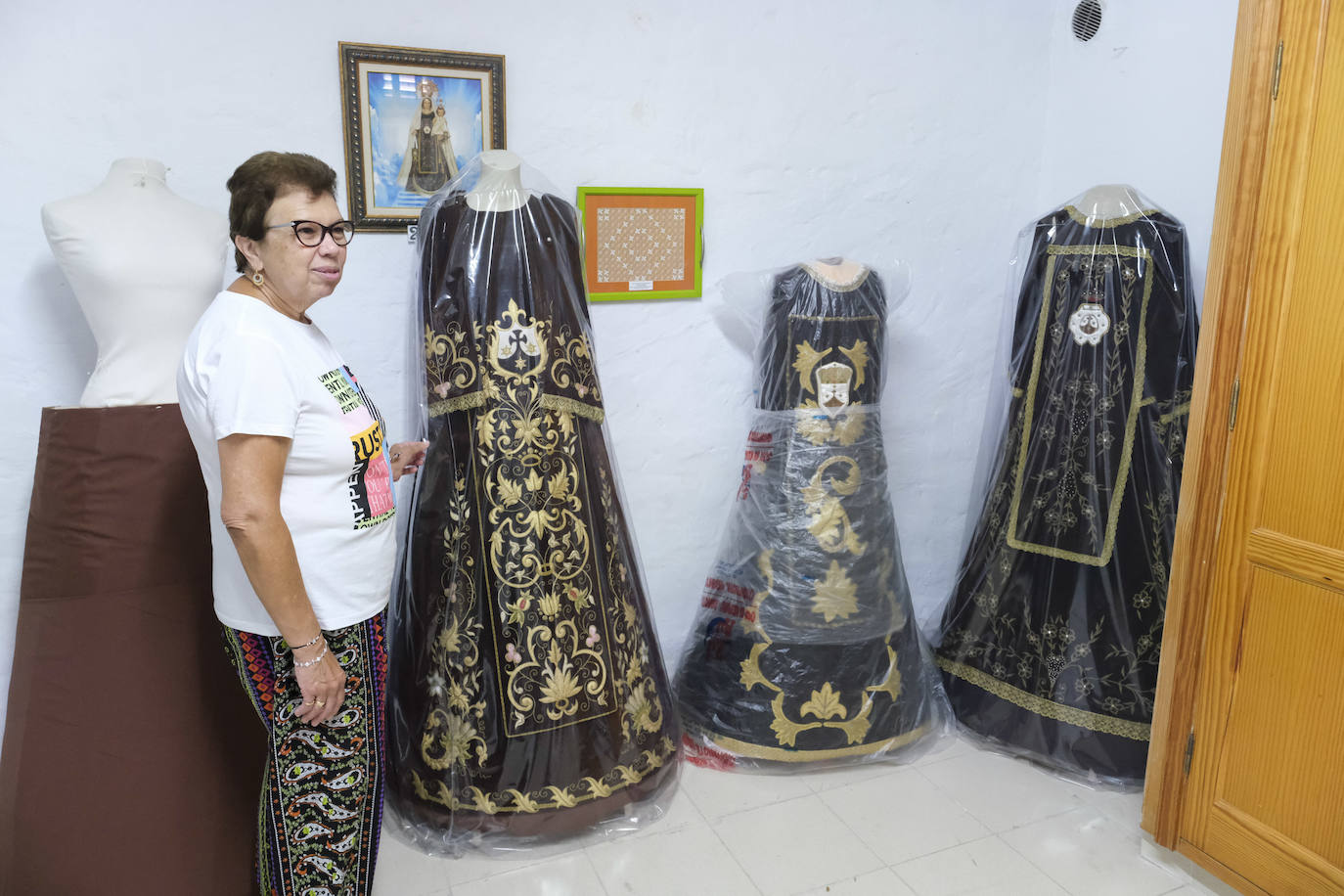 Imagen principal - Arriba, con los trajes de la Virgen del Carmen. Abajo a la izquierda, muestra el vestido más antiguo del niño. A la dereecha, en su estreno como camarera de la imagen en 1991. 
