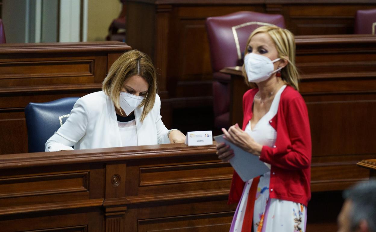 La presidenta de los populares en Canarias, Australia Navarro, pasa junto a la consejera de Derechos Sociales. 