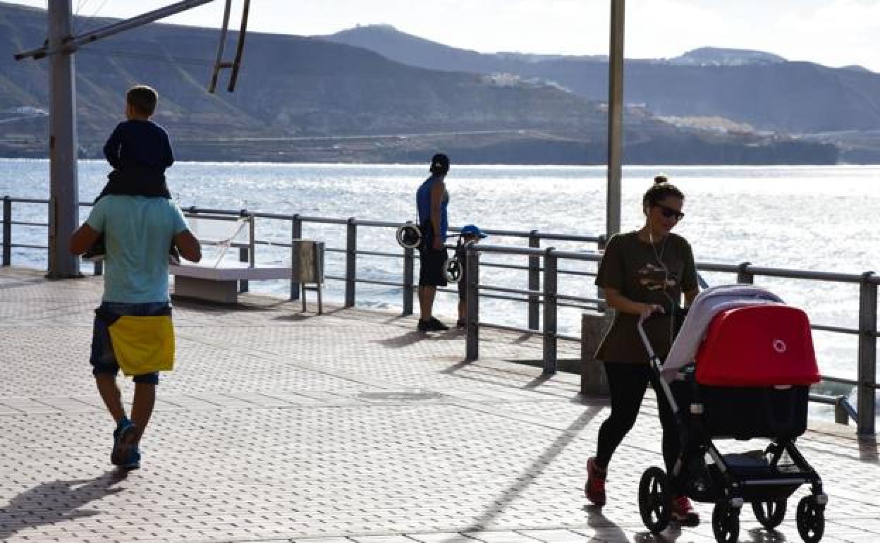 Imagen de archivo varias personas paseando con niños en el paseo de Las Canteras.