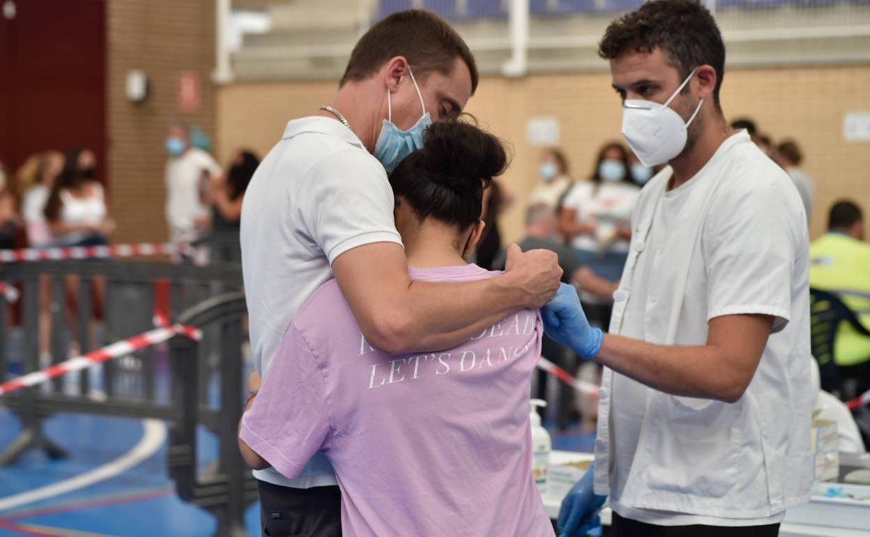 Una adolescente se abraza a un familiar tras vacunarse en Alcantarilla (Murcia).